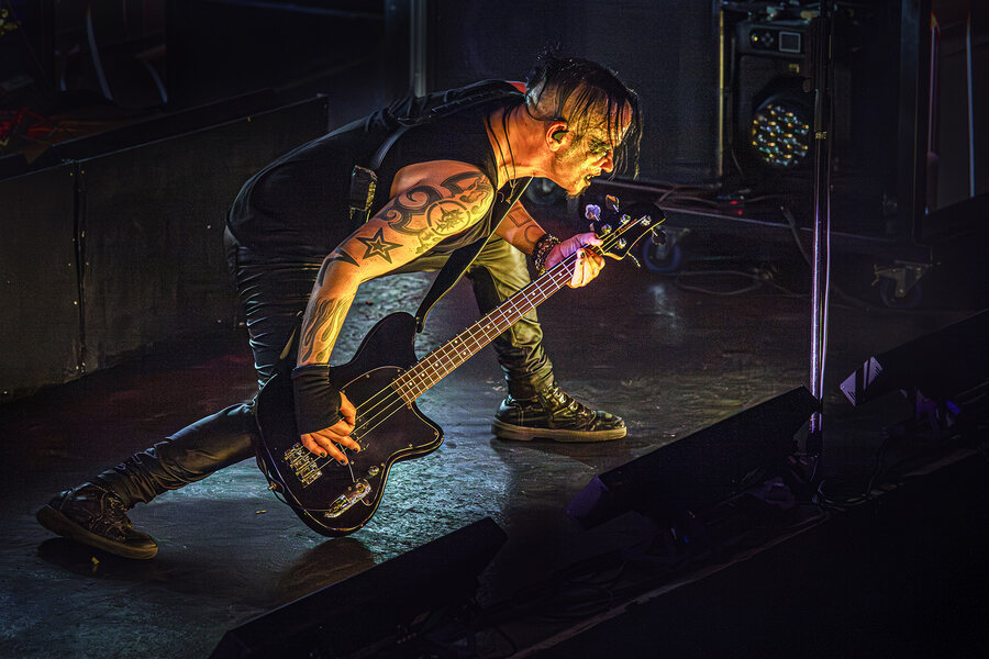 Bassist Slick Prolidol von Remode tief gebeugt im Gegenlicht auf der Bühne der Großen Freiheit 36 in Hamburg